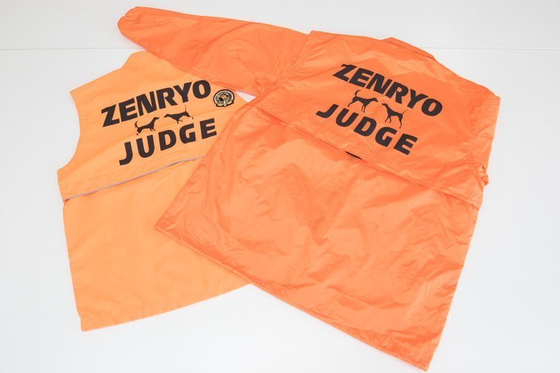 背中には審査員を表す「JUDGE」と全日本狩猟倶楽部の略称、英ポインターと英セターのトレードマークをプリント